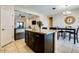 Kitchen island with granite countertops, dark wood cabinets, and tile flooring at 2185 N Beverly Pl, Buckeye, AZ 85396