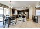 Stylish kitchen and dining area featuring dark cabinets, an island, and stainless steel appliances at 2185 N Beverly Pl, Buckeye, AZ 85396