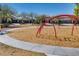 Neighborhood playground features swings and a walking path surrounded by mature trees at 2185 N Beverly Pl, Buckeye, AZ 85396