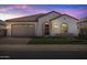 Charming single-story home with tile roof, arched entryway and manicured lawn, lit by outdoor lights at 2887 W Chevelon Dr, Queen Creek, AZ 85144