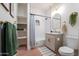 Bright bathroom featuring subway tile shower/tub, open shelves, neutral vanity, and elegant fixtures at 291 N Washington St, Chandler, AZ 85225