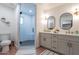 Bathroom featuring a glass shower stall, double sink vanity, and modern lighting fixtures at 291 N Washington St, Chandler, AZ 85225