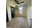 Simple bedroom with wood-look floors, window, ceiling fan, and dark closet doors at 291 N Washington St, Chandler, AZ 85225