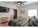 Bedroom with black metal frame bed, side tables, decorations, light colored wood floors, and a bathroom at 291 N Washington St, Chandler, AZ 85225