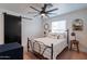 Bedroom with geometric bedding, black ceiling fan, and a sliding barn door at 291 N Washington St, Chandler, AZ 85225