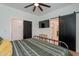 Bedroom with black metal frame bed, side tables, decorations, light colored wood floors, and a television at 291 N Washington St, Chandler, AZ 85225