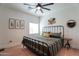 Bedroom with black metal frame bed, side tables, decorations, light colored wood floors, and a ceiling fan at 291 N Washington St, Chandler, AZ 85225