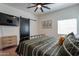 Bedroom with black metal frame bed, side tables, decorations, light colored wood floors, and a wall-mounted television at 291 N Washington St, Chandler, AZ 85225