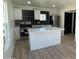 Modern kitchen with stainless steel appliances, white cabinets, island, and unique backsplash at 291 N Washington St, Chandler, AZ 85225