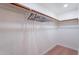 A walk-in closet features a wooden hanging rod and shelving with light-colored walls and wood-look floors at 291 N Washington St, Chandler, AZ 85225