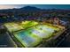 Night aerial view of lit sports courts including tennis, basketball, and a grass field with mountain backdrop at 2994 E Sports Ct, Gilbert, AZ 85298