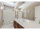 Bright bathroom featuring a white countertop, wood cabinets, and a shower with a polka dot curtain at 2994 E Sports Ct, Gilbert, AZ 85298