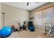 Cozy bedroom featuring a window with blinds, home gym equipment, and neutral wall colors at 2994 E Sports Ct, Gilbert, AZ 85298