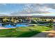 Scenic golf course view with lush green, sand trap, water hazard, clubhouse, and mountain range in background at 2994 E Sports Ct, Gilbert, AZ 85298