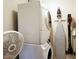 Laundry room with stacked washer and dryer, ironing board, and vacuum cleaner at 3041 S Country Club Way, Tempe, AZ 85282