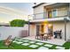 Spacious patio with dining set, grill, artificial grass, and white pavers, complemented by an upper-level balcony and modern architecture at 3041 S Country Club Way, Tempe, AZ 85282