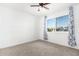 Bedroom with a ceiling fan, carpeted floor, and large window with floral curtains at 332 N 25Th St, Mesa, AZ 85213