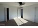 Spacious bedroom with neutral carpet, ceiling fan, and two access doors at 332 N 25Th St, Mesa, AZ 85213
