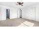 Spacious bedroom with a ceiling fan, carpet, and multiple closets at 332 N 25Th St, Mesa, AZ 85213