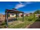 The backyard gazebo has a table, brick floor, and grass and bushes surrounding it at 332 N 25Th St, Mesa, AZ 85213