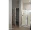 Bright bathroom features a storage cabinet and glass enclosed shower with a seat at 37180 W Mondragone Ln, Maricopa, AZ 85138