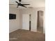 Bedroom featuring carpet floors, neutral walls, a television, and ensuite bath at 37180 W Mondragone Ln, Maricopa, AZ 85138