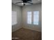 Neutral bedroom features three windows and a ceiling fan at 37180 W Mondragone Ln, Maricopa, AZ 85138