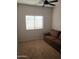 Bedroom with neutral carpet, ceiling fan, and bright window; a perfect guest room at 37180 W Mondragone Ln, Maricopa, AZ 85138