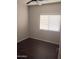 Bright bedroom featuring a ceiling fan, wood-look floors, and natural light from the window at 37180 W Mondragone Ln, Maricopa, AZ 85138