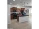 Modern kitchen with dark appliances, granite countertops, a central island, and rich wood cabinetry for a sleek, functional space at 37180 W Mondragone Ln, Maricopa, AZ 85138