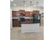 Well-equipped kitchen showcasing stainless steel appliances, dark countertops, wooden cabinetry, and pendant lighting at 37180 W Mondragone Ln, Maricopa, AZ 85138