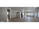 Spacious living area with tile flooring, neutral walls and an arched doorway at 37180 W Mondragone Ln, Maricopa, AZ 85138