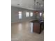 Bright open-concept living area with stylish pendant lighting, neutral walls, and tile flooring creating a versatile living space at 37180 W Mondragone Ln, Maricopa, AZ 85138