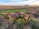 Expansive aerial view of a luxury estate with a red tile roof, desert landscaping, and golf course at 42171 N Saguaro Forest Dr, Scottsdale, AZ 85262