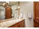 A bathroom features a stone countertop, wood cabinetry, and a decorative mirror at 42171 N Saguaro Forest Dr, Scottsdale, AZ 85262