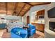 Cozy bedroom with wood-beamed ceiling, kitchenette, fireplace, and charming blue armchairs at 42171 N Saguaro Forest Dr, Scottsdale, AZ 85262