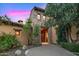 Charming home features a stone exterior, a wooden front door, and lush greenery at 42171 N Saguaro Forest Dr, Scottsdale, AZ 85262