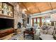 Comfortable living area showcasing a stone fireplace, wood ceiling, and a picturesque view at 42171 N Saguaro Forest Dr, Scottsdale, AZ 85262