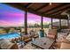 Covered outdoor living space featuring ample seating, a beautiful pool with floral accents, and stunning sunset views at 42171 N Saguaro Forest Dr, Scottsdale, AZ 85262