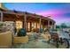 Covered patio with stone accents, comfortable seating, and well-maintained desert landscaping, ideal for enjoying the outdoor ambiance at 42171 N Saguaro Forest Dr, Scottsdale, AZ 85262