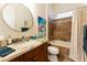 Bathroom features a granite countertop vanity, round mirror, and shower-tub combo at 4320 E Ficus Way, Gilbert, AZ 85298