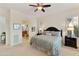 Spacious main bedroom featuring a ceiling fan, plantation shutters and connecting bathroom at 4320 E Ficus Way, Gilbert, AZ 85298