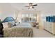 Bright main bedroom with white dresser, comfortable sitting area, large windows, and ceiling fan at 4320 E Ficus Way, Gilbert, AZ 85298