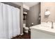 This bathroom features a wood floor, white cabinets, shower with curtain, toilet, and floating shelves at 4808 N 24Th St # 1427, Phoenix, AZ 85016