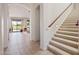 Inviting hallway with stairway, neutral tile flooring, and views to living area at 511 W Cherrywood Dr, Sun Lakes, AZ 85248