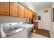 Spacious laundry room with tile floors, full size washer and dryer, cabinets, and a utility sink at 511 W Cherrywood Dr, Sun Lakes, AZ 85248