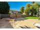 Large backyard offers ample space with tiled patio, fire pit, water feature and grassy areas at 5291 W Angela Dr, Glendale, AZ 85308