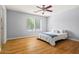 Bright bedroom with hardwood floors, a ceiling fan, and a large window providing natural light at 5291 W Angela Dr, Glendale, AZ 85308