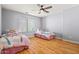 Bright bedroom featuring two beds, a ceiling fan, and a large window with natural light at 5291 W Angela Dr, Glendale, AZ 85308