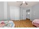 Open-concept bedroom, featuring wood floors, large closet, ceiling fan, and an open doorway to another room at 5291 W Angela Dr, Glendale, AZ 85308